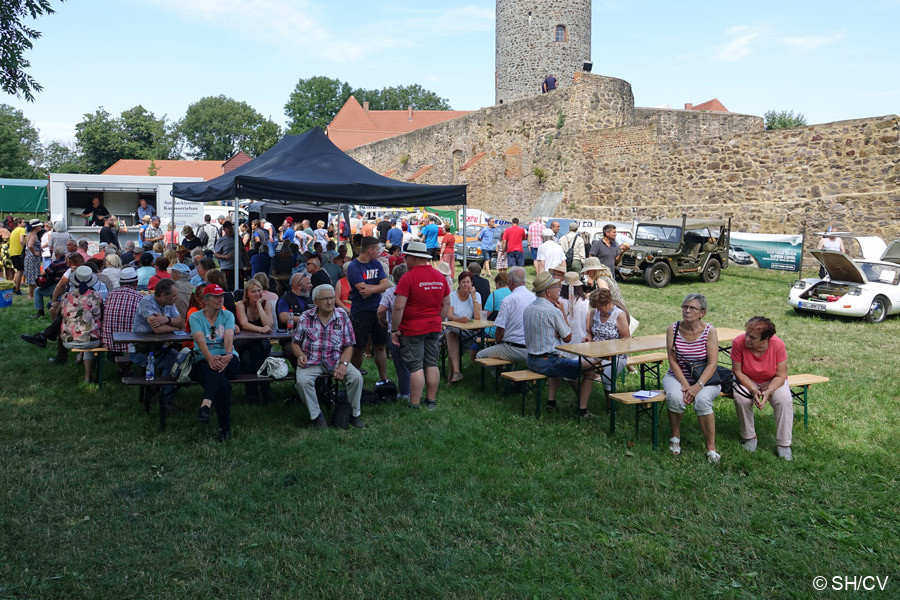 Bild: Viele Besucher und Gäste suchten schattige Plätzchen auf dem Schloßparkplatz, bevor die Fahrerbesprechung aus die Ausfahrt nach Biendorf startete.